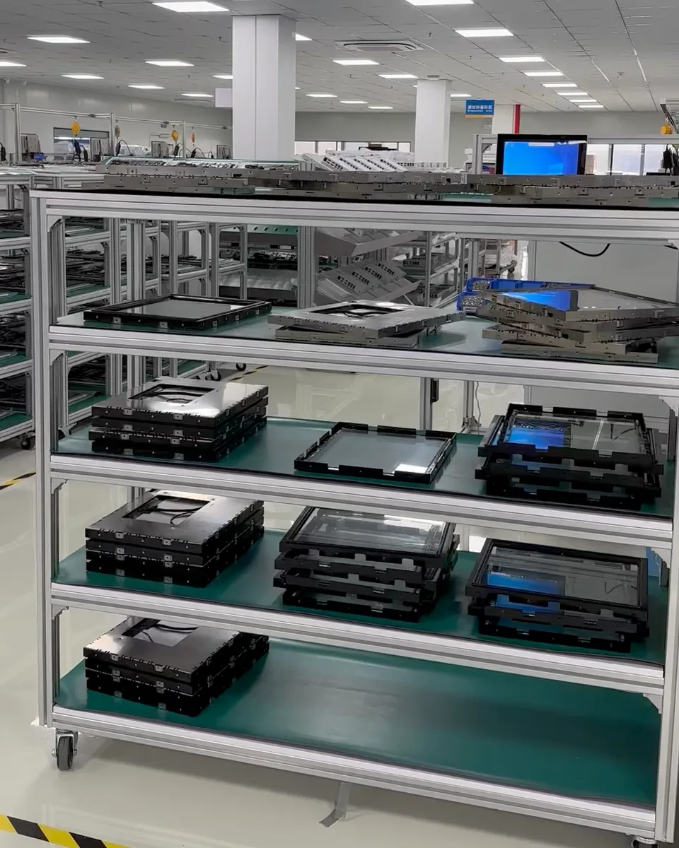 Aicotek production floor: racks of panel PC assemblies on a mobile trolley in the factory hall